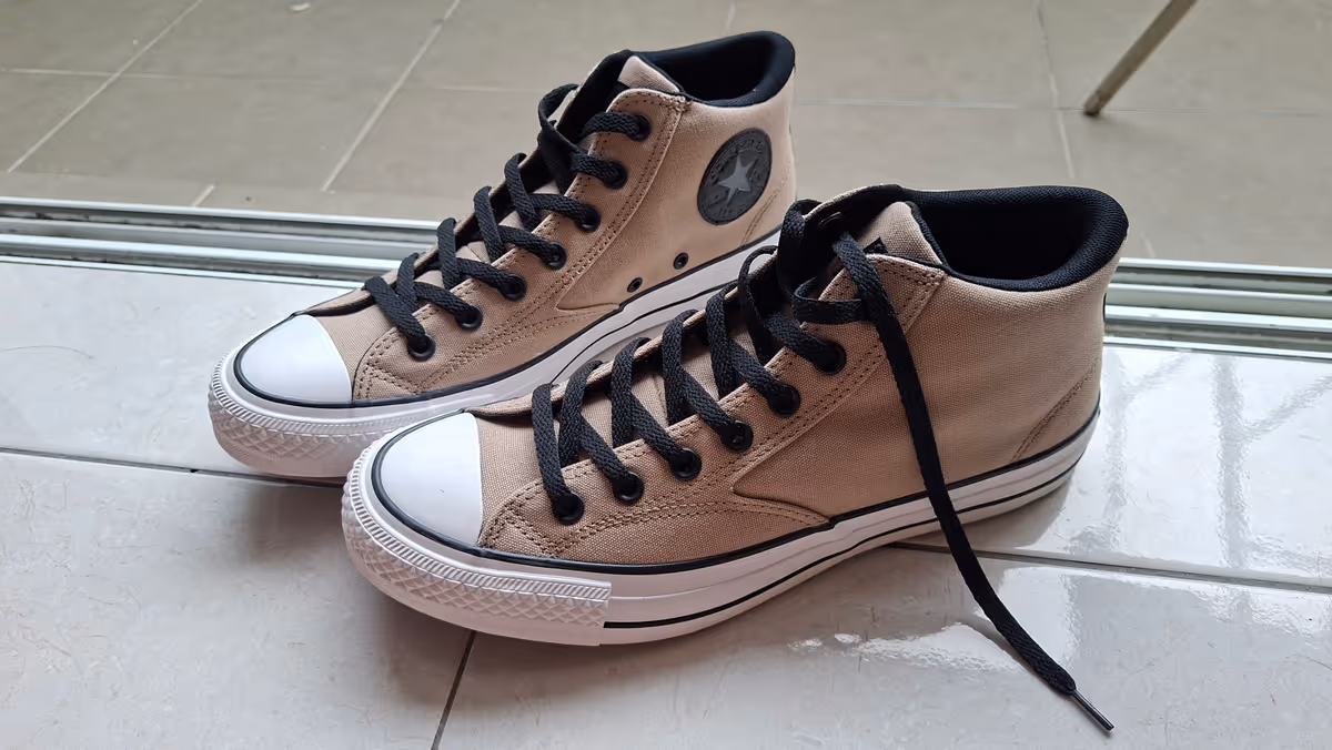 A brown Converse shoes with black lace.