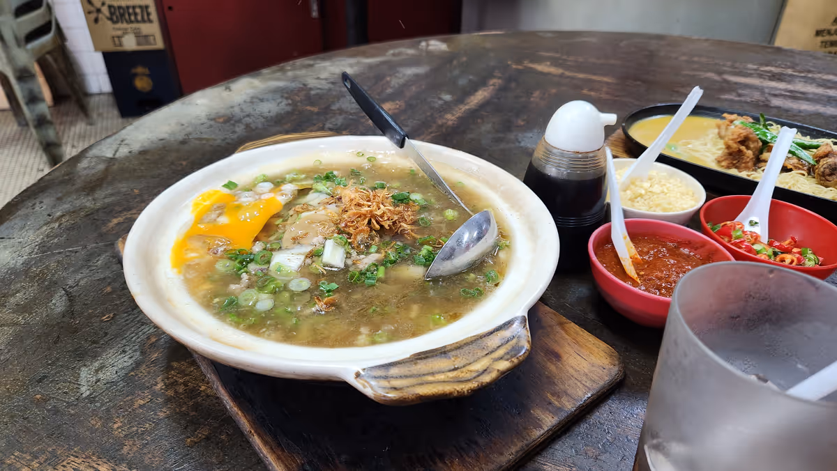 Silver needle noodles served in a clay pot with condiments