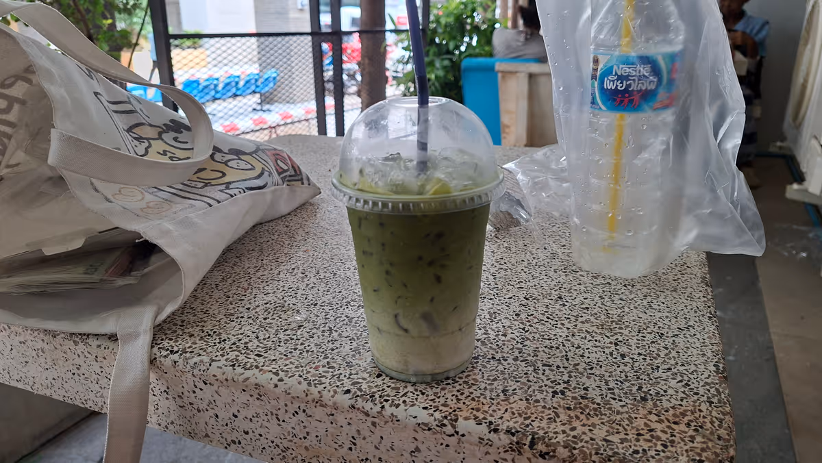 Matcha Latte, greentea and milk served in a plastic cup.
