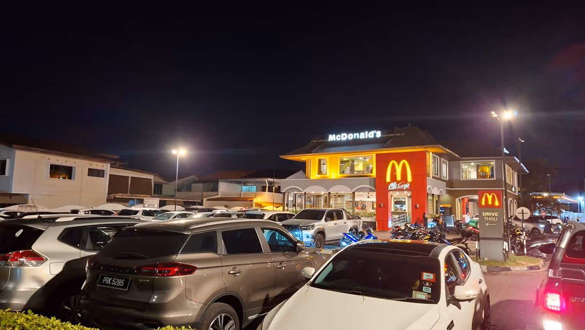 Cars parked in front of a McDonald's store at night