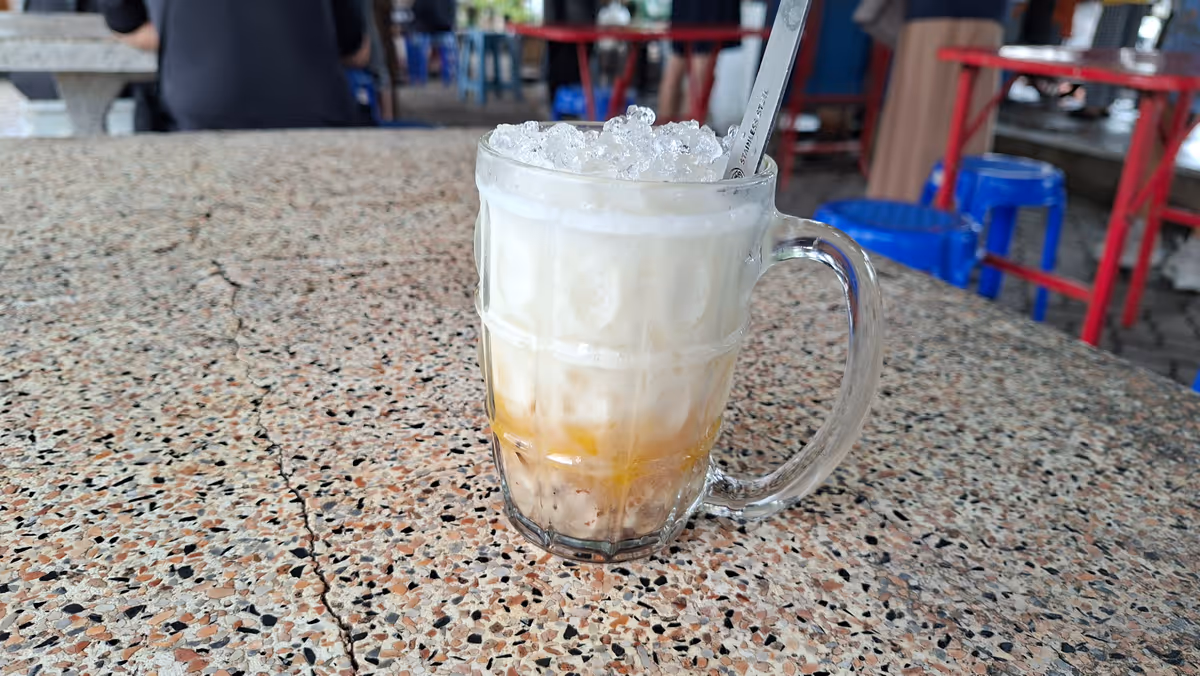 A white coconut milk of a dessert. Served in a transparent cup