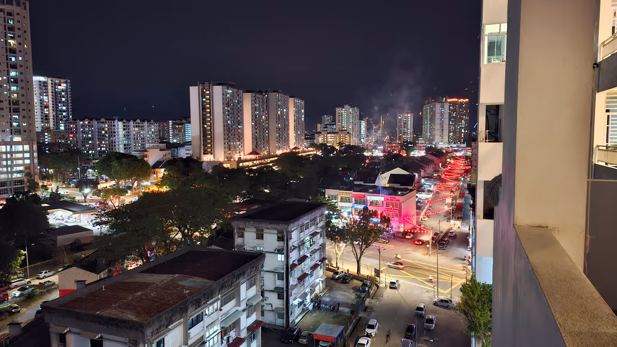 A night view of condominiums and high-rise buildings, with Chinese New Year lantern decorations along the street on the right