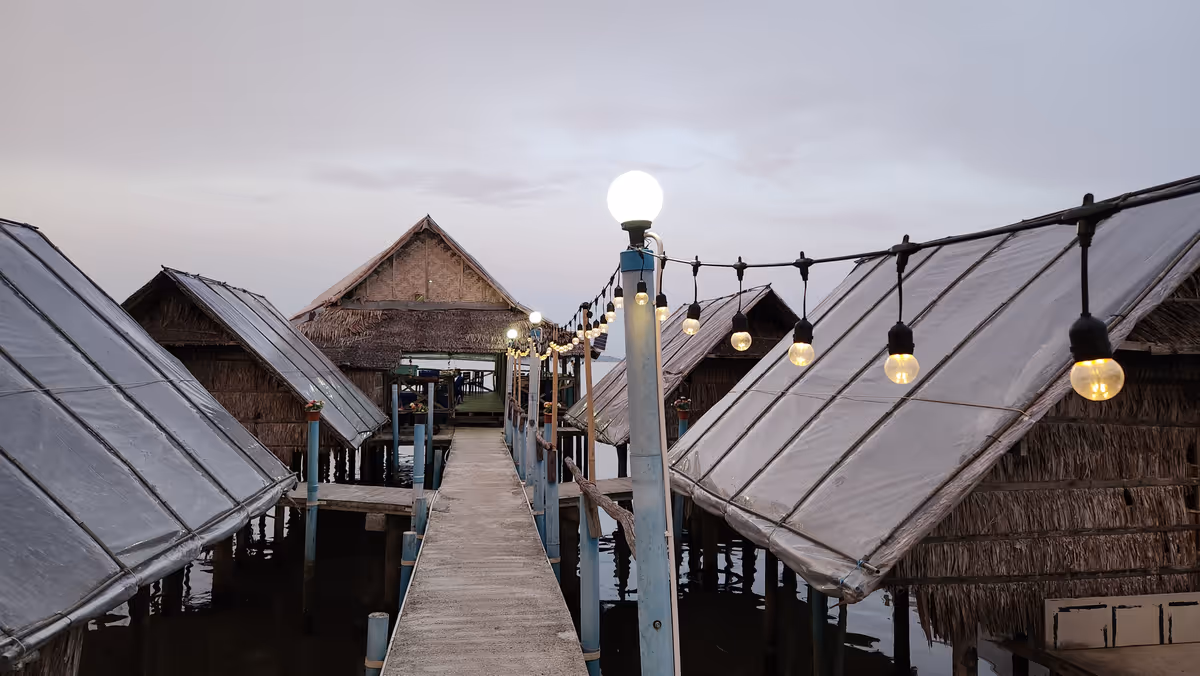 A walkway with streetlight above lake.