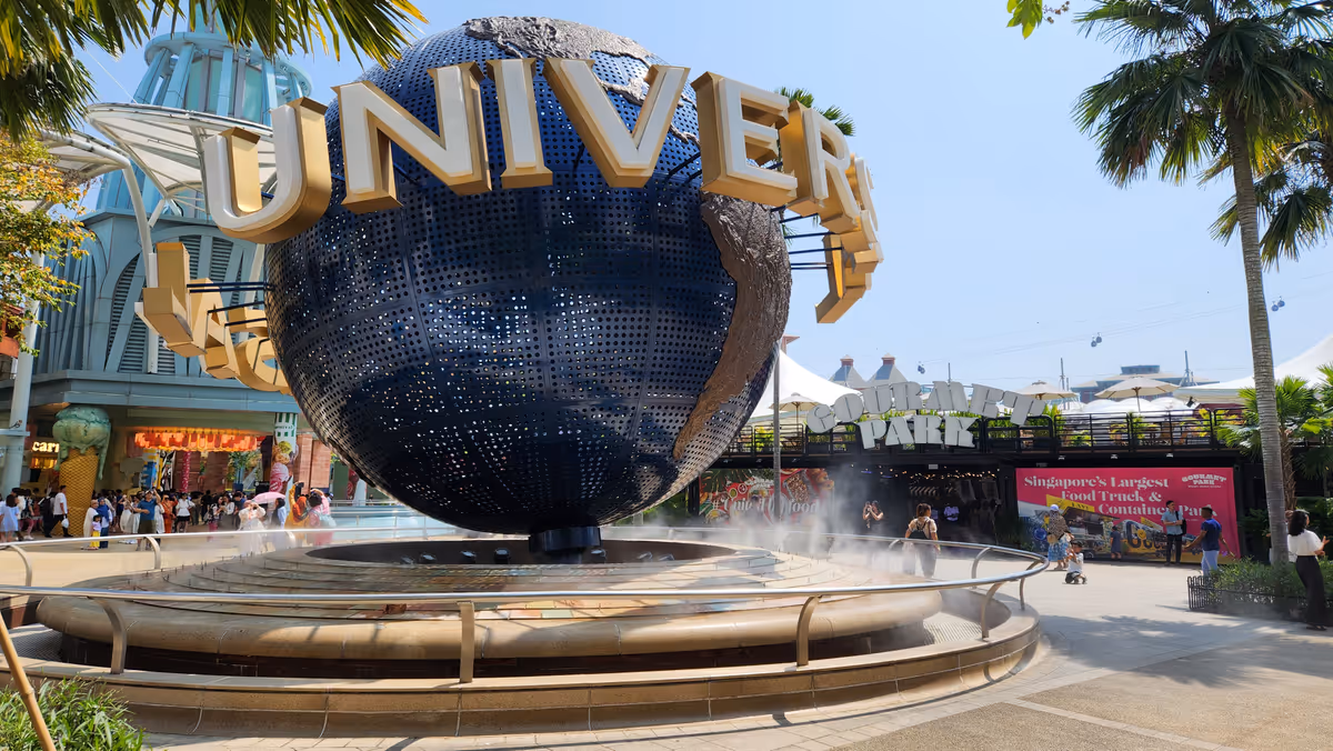 A blue giant globe with a word Universal Studio and a small fountain around the globe.